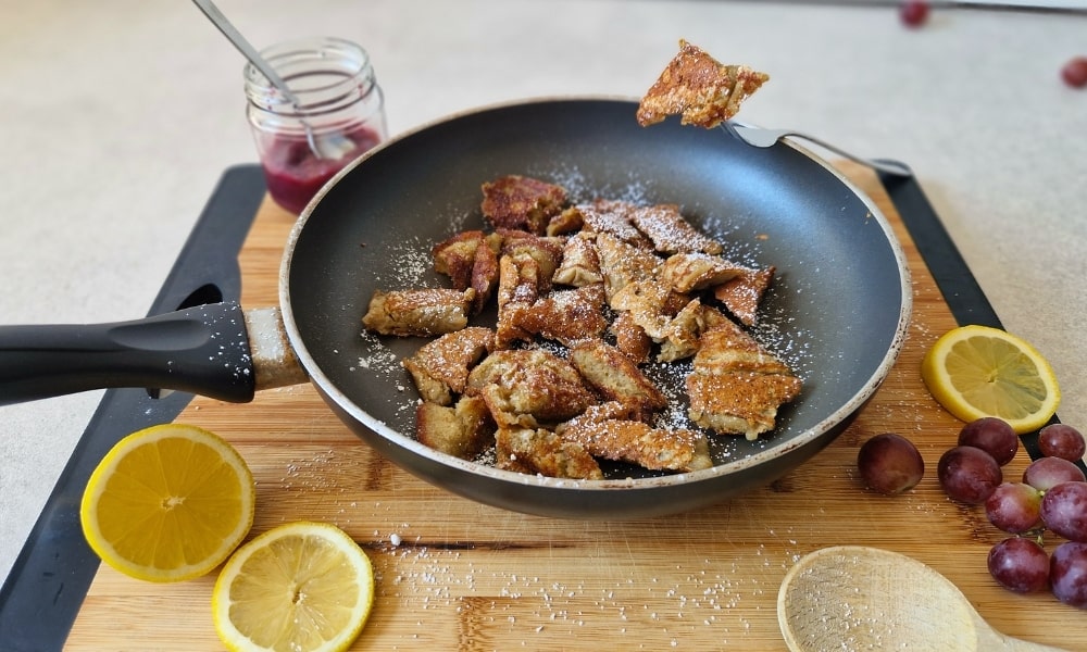 Protein Kaiserschmarrn mit Puderzucker in einer Pfanne mit Deko