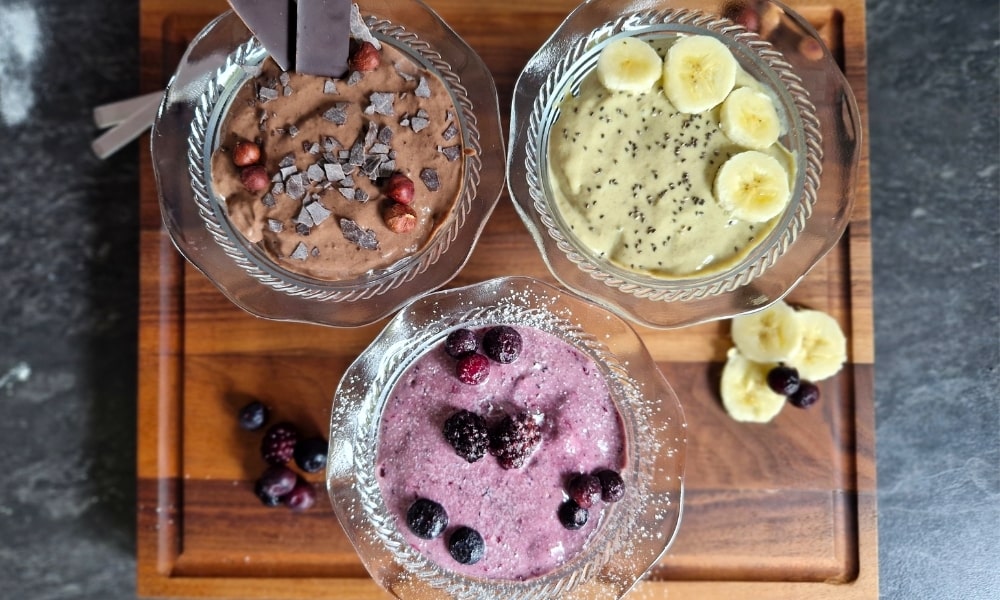 Drei verschiedene vegane Protein Puddings (Beere, Vanille und Schokolade) mit passenden Toppings