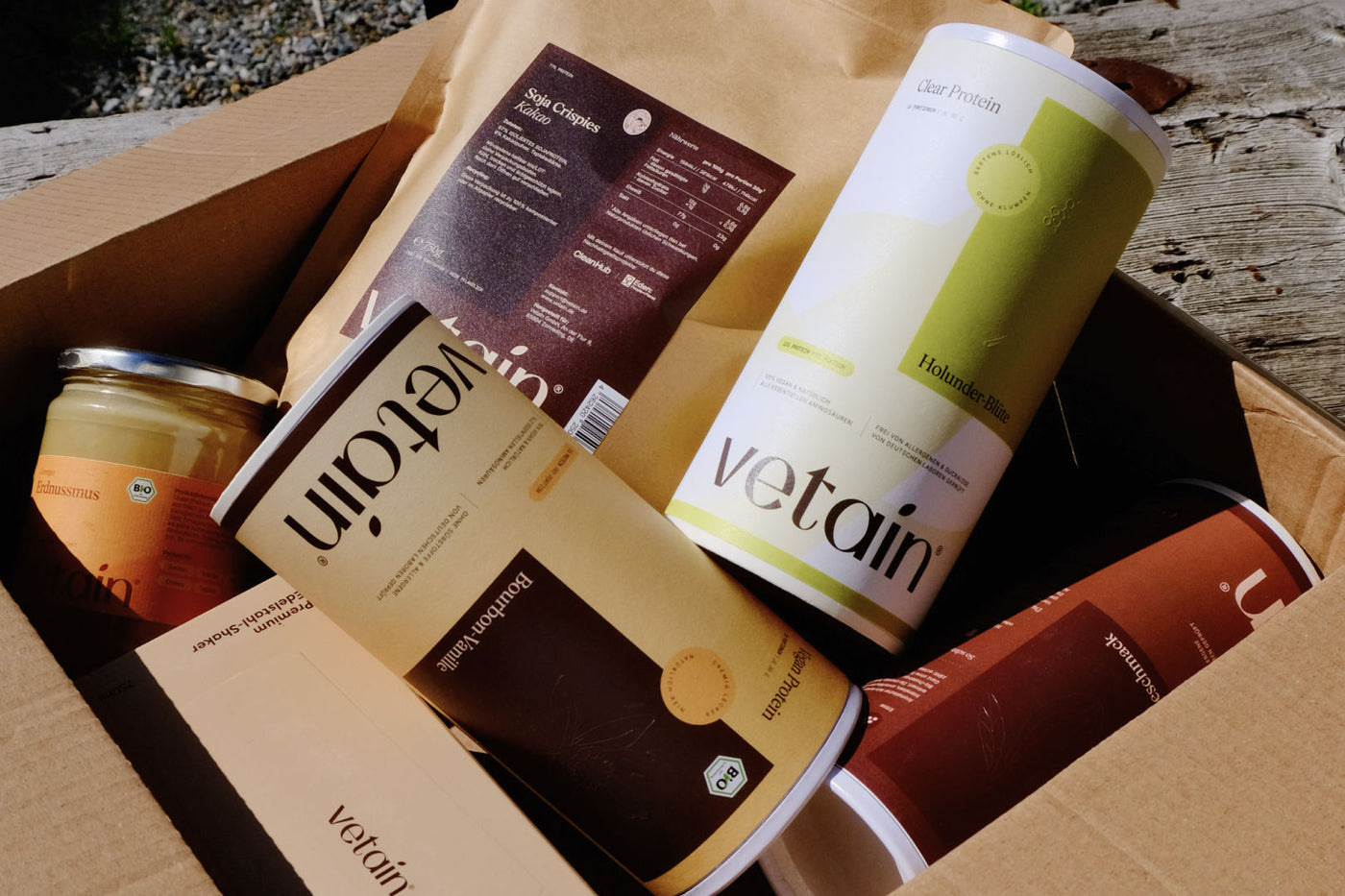 Vetain vegan Protein Dosen und Clear Protein Dosen mit Toppings in einem Versandkarton