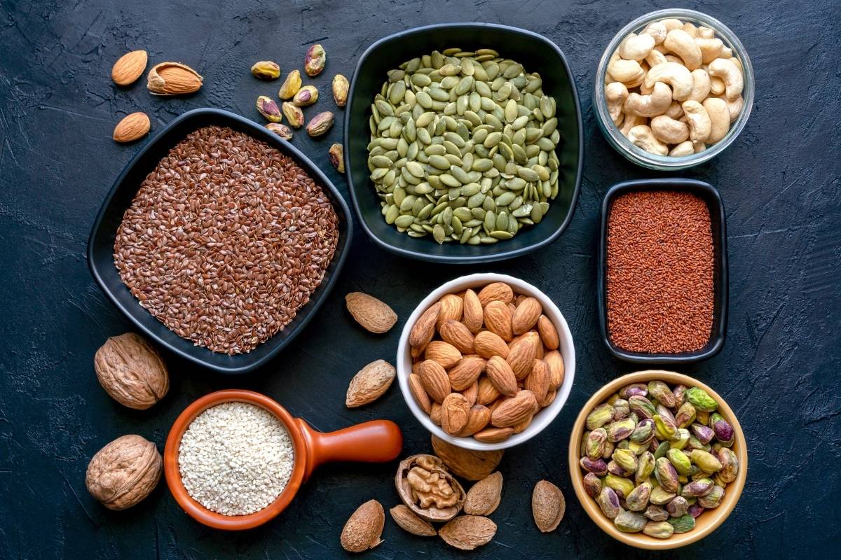 Schüsseln mit verschiedenen Lebensmitteln mit viel Protein auf dunklem Hintergrund