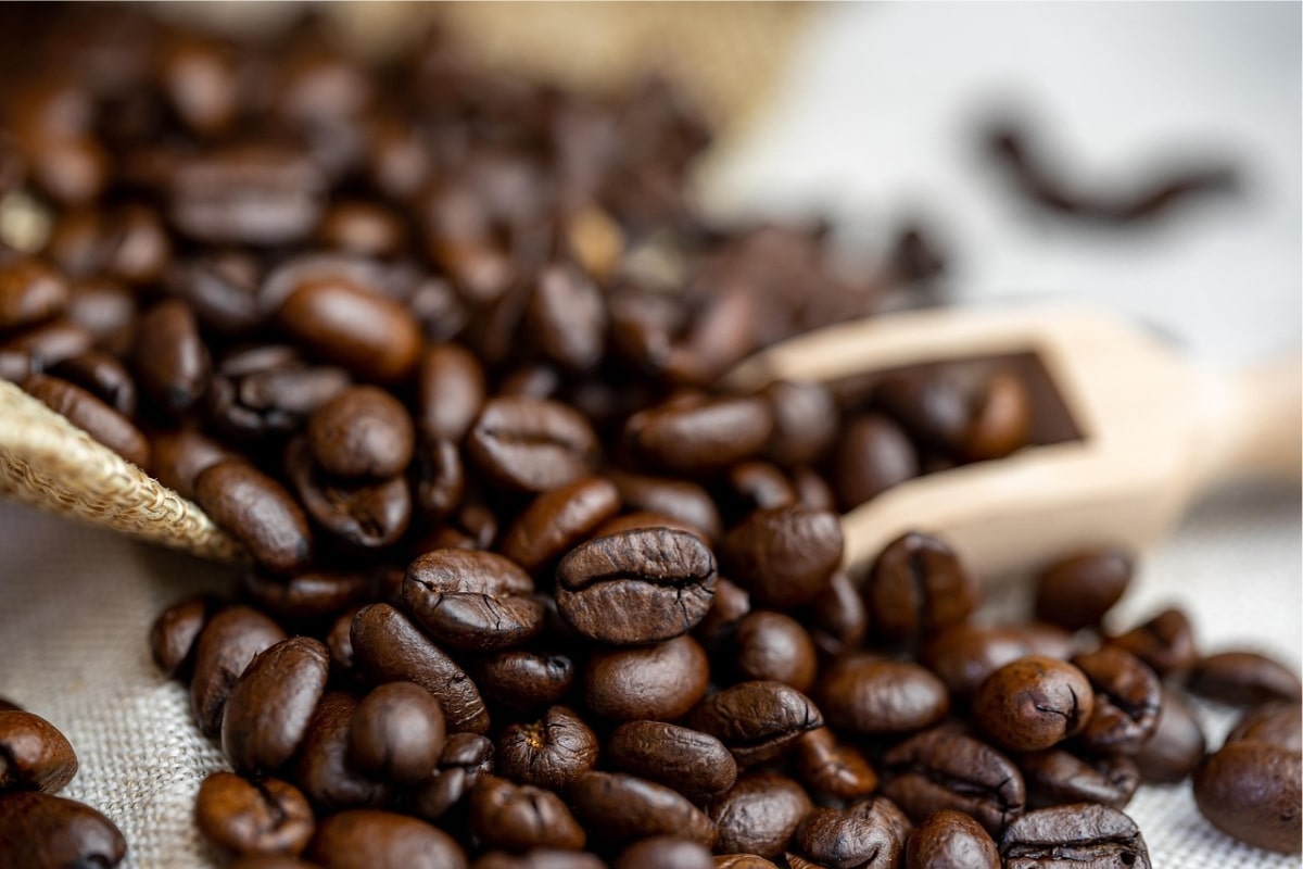 Kaffeebohnen fallen aus einem liegenden Sack