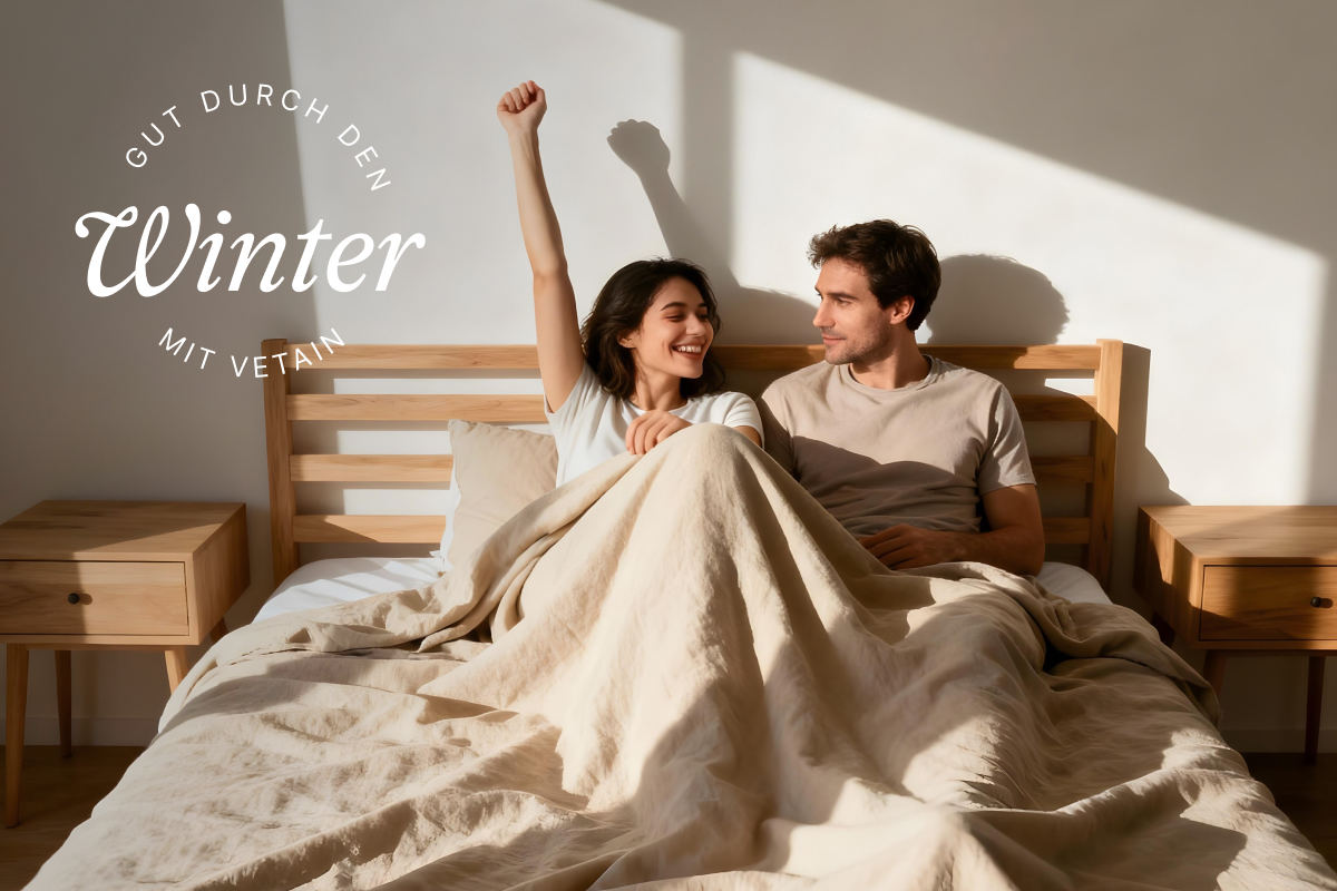 Zwei Menschen liegen im Bett, die Frau streckt ihre Faust fröhlich in die Höhe