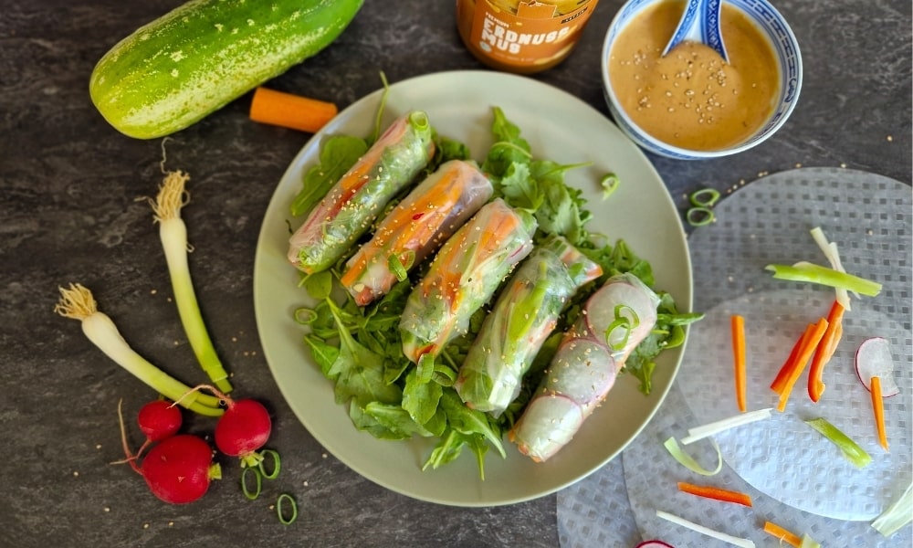 Sommerrollen auf einem Rucolabett mit Gemüse und einer Erdnusssauce mit Vetains Erdnussmus