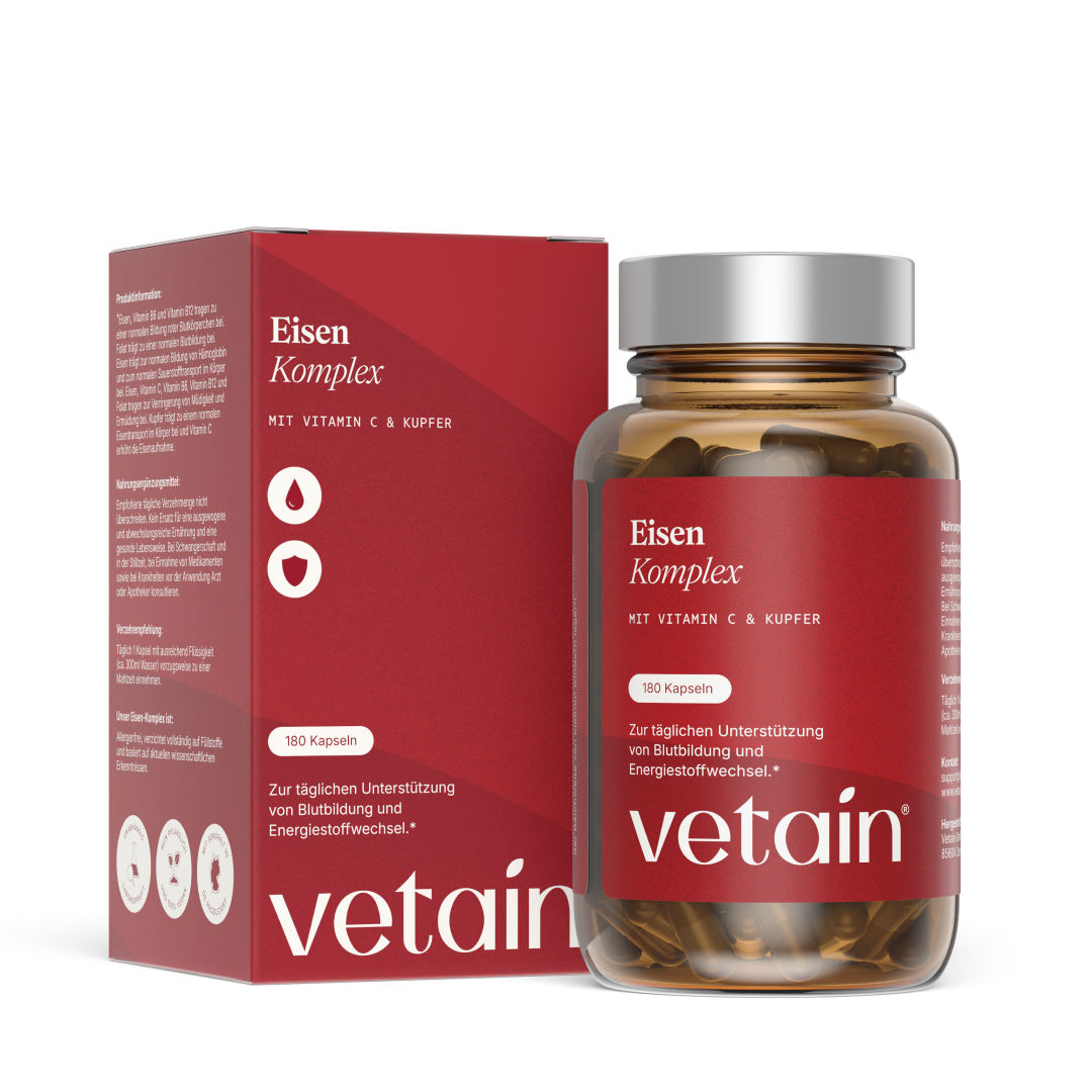 Vetains Eisenkomlpex Kapseln im hochwertigen Braunglas. Schräg dahinter der nachhaltige Verpackungskarton.