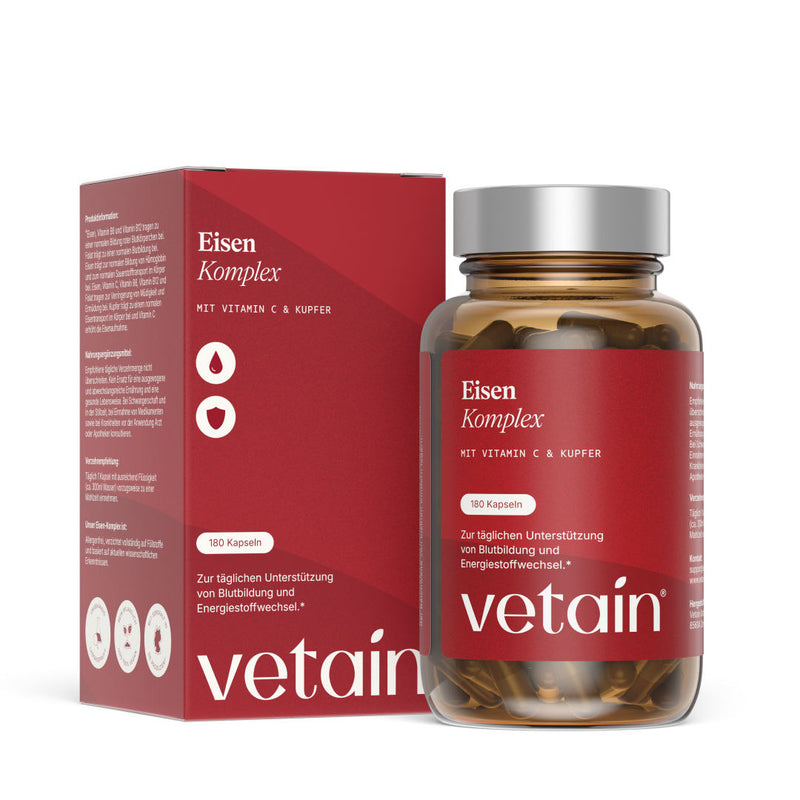 Vetains Eisenkomlpex Kapseln im hochwertigen Braunglas. Schräg dahinter der nachhaltige Verpackungskarton.