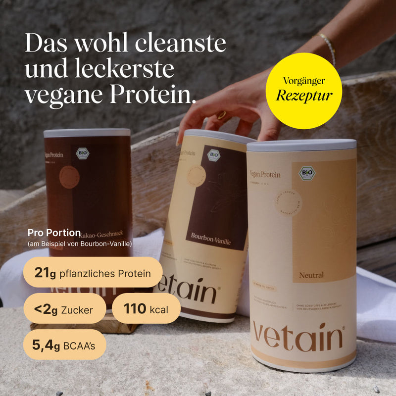 Das wohl leckerste und cleanste vegane Protein von Vetain, in alter Rezeptur. 21g pflanzliches Protein pro Portion, unter 2g Zucker, 110kcal und 5,4g BCAA's. Drei Dosen stehen nebeneinander und eine weibliche Hand greift nach der Vanille Proteinpulver Dose