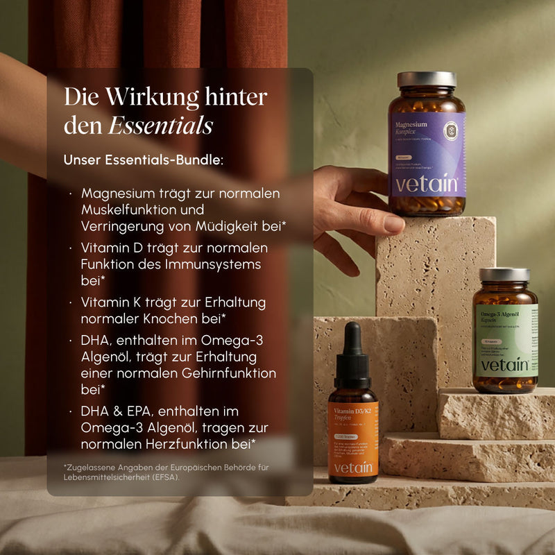 Lifestyle photo with Vetain products on stone pedestals. Text overlay "The effect behind the essentials": Magnesium for muscle function & less fatigue, Vitamin D for the immune system, Vitamin K for bones, DHA & EPA from omega-3 algae oil for brain and heart function (EFSA-approved claims)