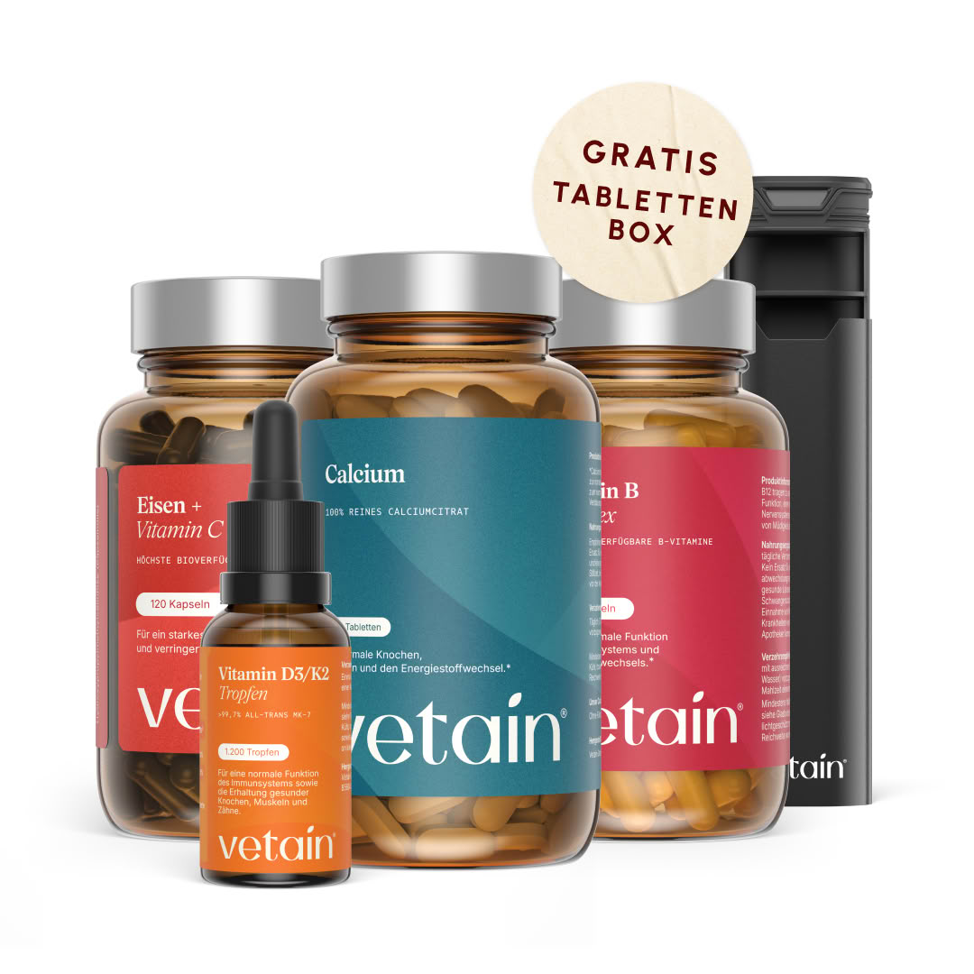 Vetain Women Essentials Bundle: Eisen + Vitamin C Kapseln, Calcium Tabletten , Vitamin B Komplex Kapseln und Vitamin D3/K2 Tropfen in braunen Glasflaschen mit silbernem Deckel, daneben eine schwarze Premium-Tablettenbox mit „Gratis Tablettenbox"-Badge