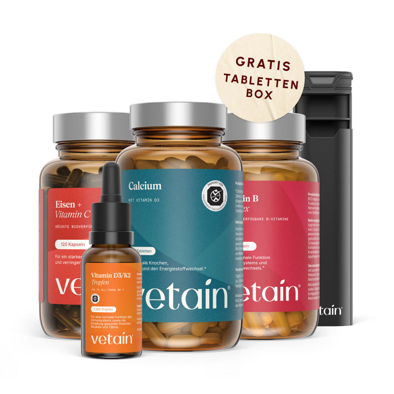 Vetain Women Essentials Bundle: Eisen + Vitamin C Kapseln, Calcium mit Vitamin D3, Vitamin B Komplex, Vitamin D3/K2 Tropfen und schwarze Vetain Tablettenbox mit Sticker „Gratis Tablettenbox“, auf weißem Hintergrund.