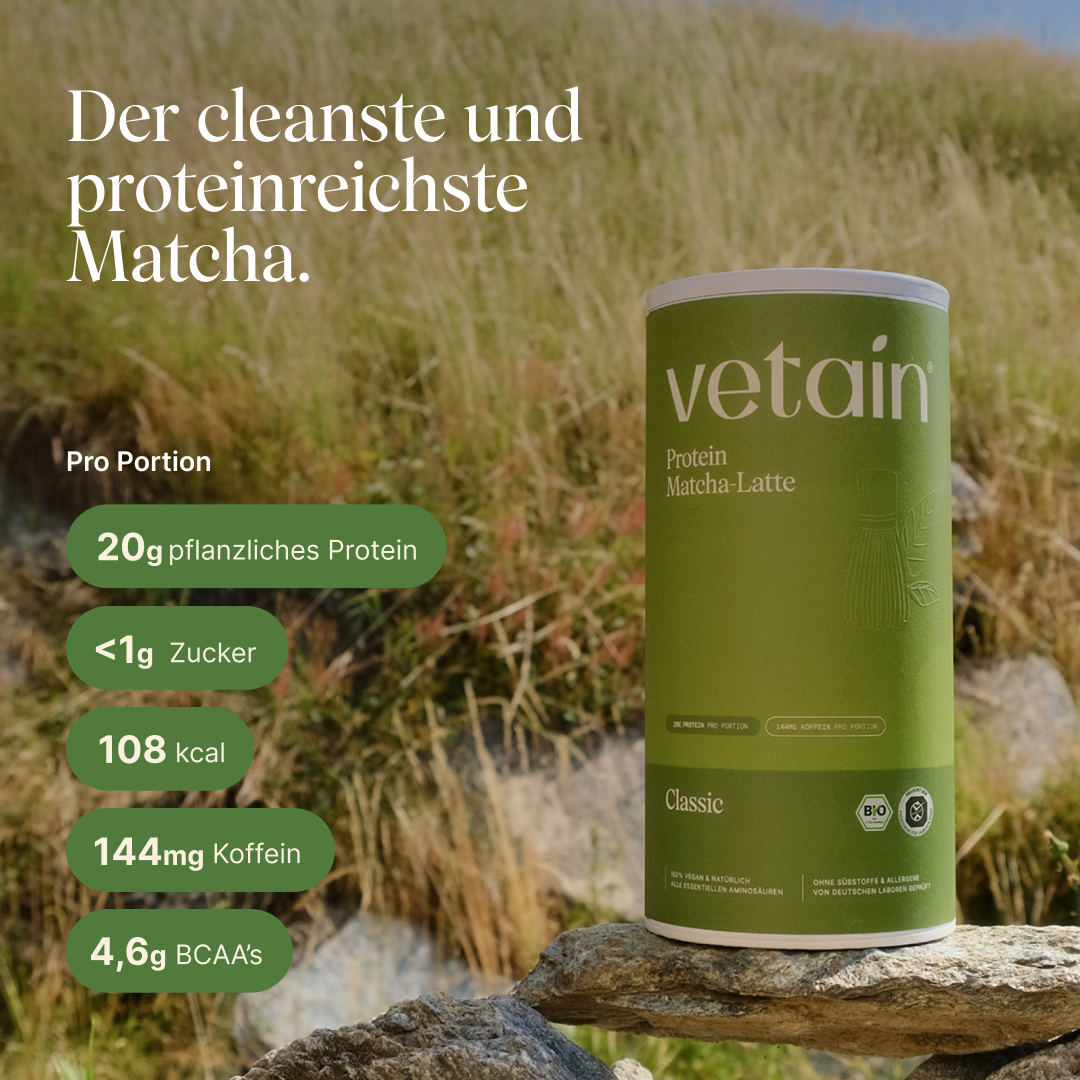 Vetain Vegan Protein Matcha-Latte Dose (Classic) auf Felsen vor einer Wiesenlandschaft. Text: „Der cleanste und proteinreichste Matcha." Pro Portion: 20g pflanzliches Protein, <1g Zucker, 108 kcal, 144mg Koffein, 4,6g BCAAs.