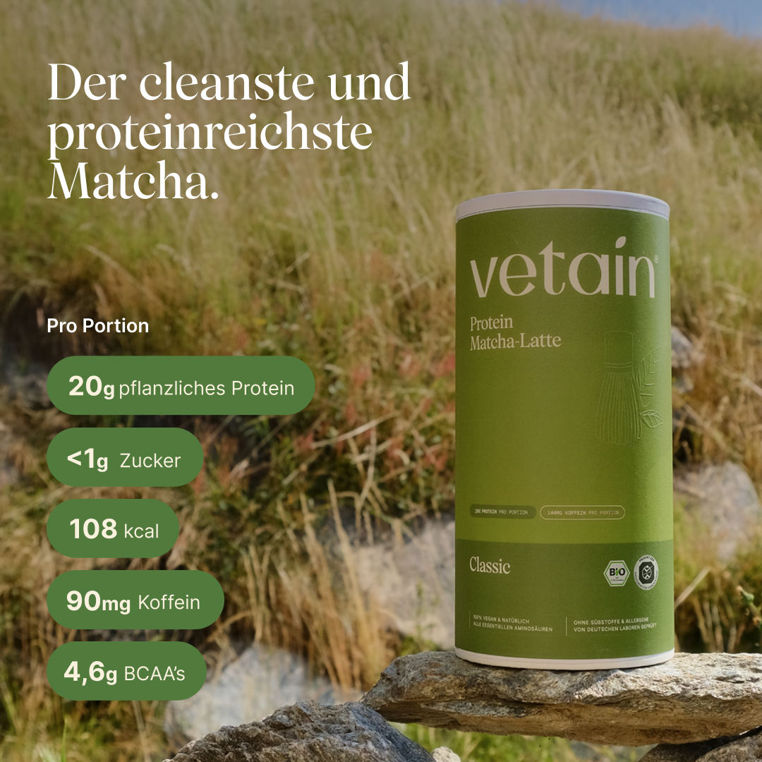 Vetain Protein Matcha-Latte Classic (Bio) auf einem Stein in einer sonnigen Graslandschaft. Text: „Der cleanste und proteinreichste Matcha.“ Nährwerte pro Portion: 20g pflanzliches Protein, <1g Zucker, 108 kcal, 90mg Koffein, 4,6g BCAAs.