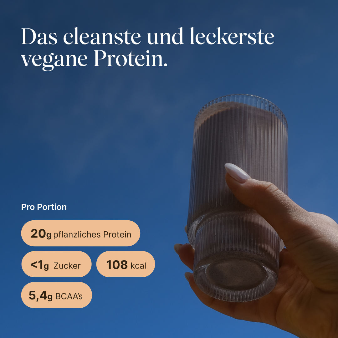 Hand holding a ribbed glass with a vegan protein shake against a blue sky. Text: “The cleanest and tastiest vegan protein.” Per serving: 20g plant-based protein, <1g sugar, 108 kcal, 5.4g BCAAs.