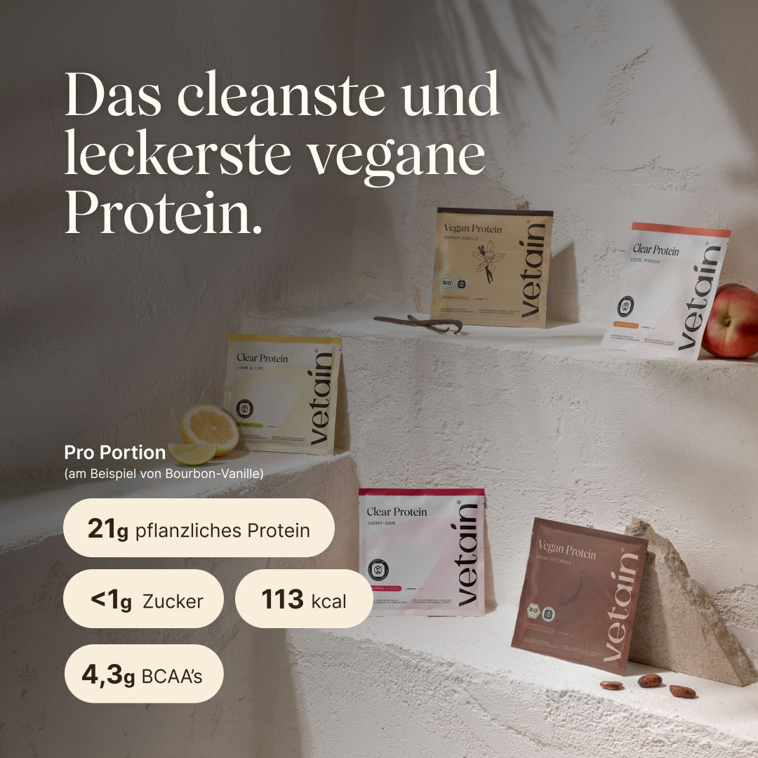 Five vetain sample packs on tiered stone steps: Vegan Protein Bourbon Vanilla, Clear Protein Lemon & Lime, Clear Protein Cherry Sour, Clear Protein Iced Tea Peach, and Vegan Protein Cocoa Flavor, decorated with lemon halves and cocoa beans. Text: “The cleanest and most delicious vegan protein.” Nutritional values for Bourbon Vanilla, per serving: 21 g plant-based protein, <1 g sugar, 113 kcal, 4.3 g BCAAs.