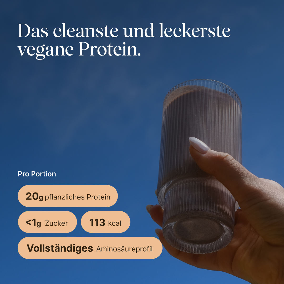 Hand holding a glass with a prepared vetain Vegan Protein Shake in hazelnut flavor against a blue sky. Headline: 'The cleanest and tastiest vegan protein.' Per serving: 20 g plant-based protein, under 1 g sugar, 113 kcal, complete amino acid profile.