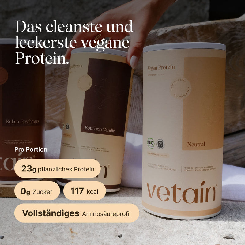 Three cans of vetain Vegan Protein side by side on a stone surface, in the foreground the Neutral flavor, behind it Bourbon Vanilla and Cocoa flavor. Headline: 'The cleanest and tastiest vegan protein.' Information per serving: 23 g plant-based protein, 0 g sugar, 117 kcal, complete amino acid profile.