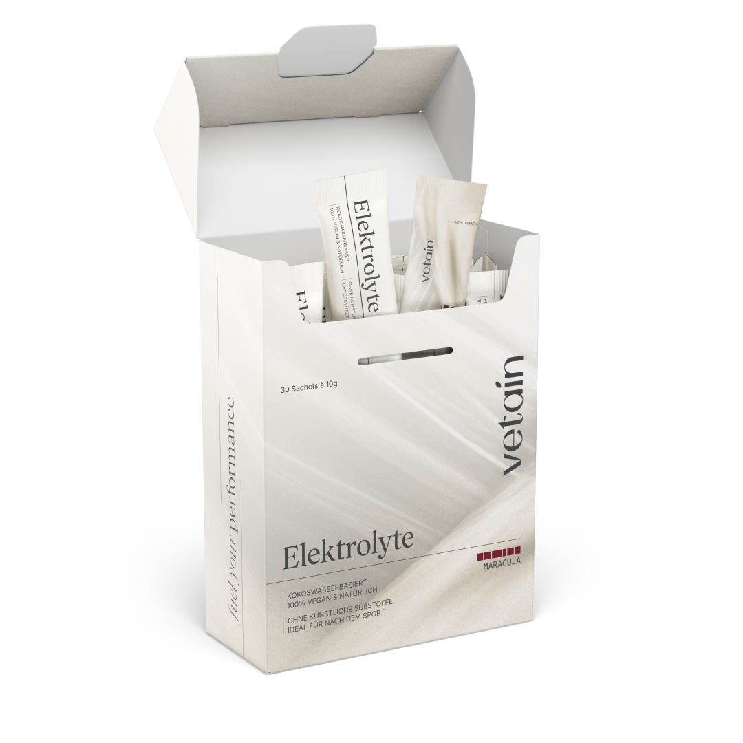 Geöffnete vetain Elektrolyte Maracuja Box (30 Sachets à 10g) auf weißem Hintergrund mit herausragenden Einzelsticks. Aufschrift: kokoswasserbasiert, 100% vegan & natürlich, ohne künstliche Süßstoffe, ideal für nach dem Sport.