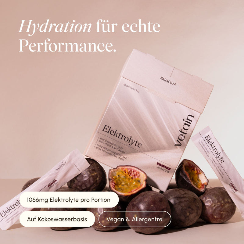 vetain Elektrolyte Maracuja Box und einzelne Sticks auf frischen Maracujas arrangiert. Text: „Hydration für echte Performance." 1066mg Elektrolyte pro Portion, auf Kokoswasserbasis, vegan & allergenfrei.
