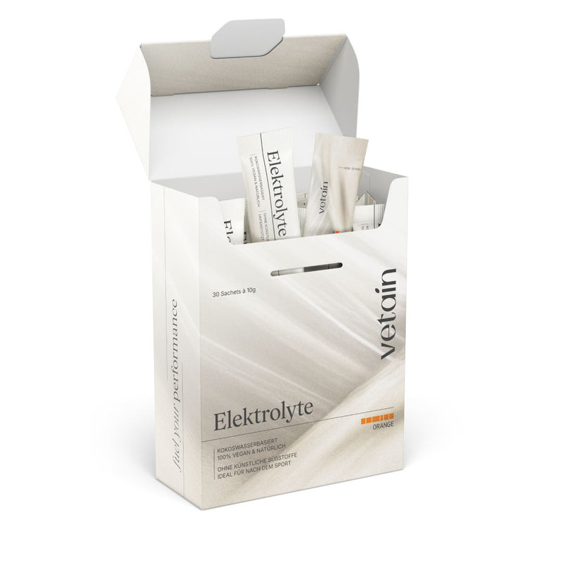 Opened vetain Electrolyte Orange Box (30 sachets of 10g) on a white background with individual sticks standing out. Inscription: coconut water-based, 100% vegan & natural, without artificial sweeteners, ideal for after sports.