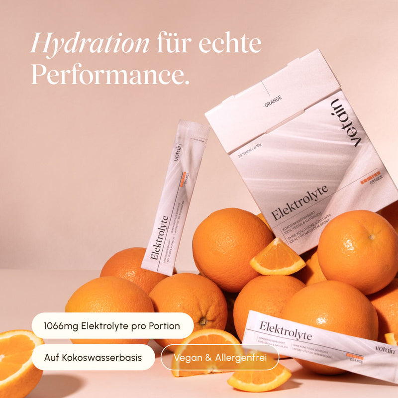 vetain Electrolytes Orange folding box with 30 sachets of 10 g each and individual sticks on a beige background, surrounded by whole and sliced oranges. Notes: 1066 mg electrolytes per serving, coconut water-based, vegan and allergen-free.