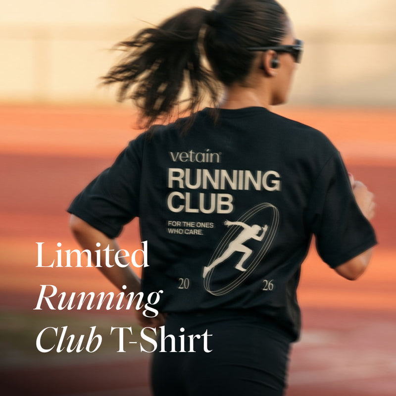 Eine Läuferin von hinten auf einer Laufbahn, die ein schwarzes T-Shirt trägt. Der Rücken des Shirts zeigt den Grafikdruck „vetain RUNNING CLUB“ mit einem Läufer-Symbol, dem Text „FOR THE ONES WHO CARE.“ und der Jahreszahl 2026. Unten links steht der Ankündigungstext „Limited Running Club T-Shirt“

