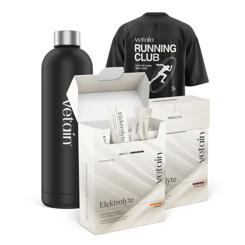 Schwarze Trinkflasche, schwarzes T-Shirt mit weißem Aufdruck "vetain RUNNING CLUB", zwei geöffnete und geschlossene Verpackungen mit Elektrolyt-Sachets in den Geschmacksrichtungen “Orange” und “Maracuja” der Marke vetain
