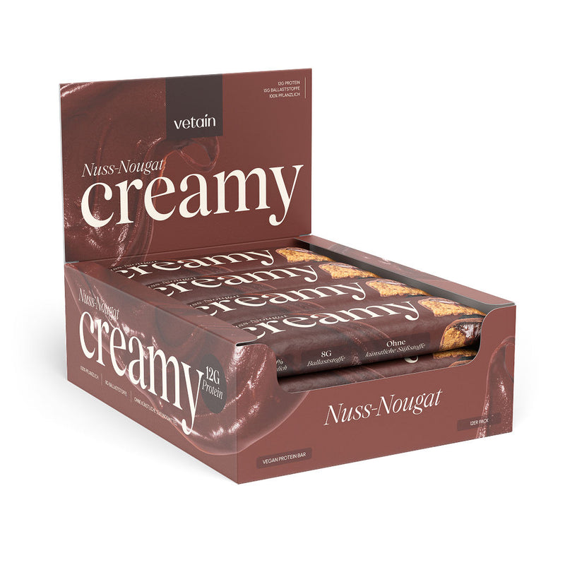 Geöffnete 12er-Displaybox „Nuss-Nougat Creamy" mit sichtbaren einzelnen Riegeln vor dunkelbraunem Hintergrund.