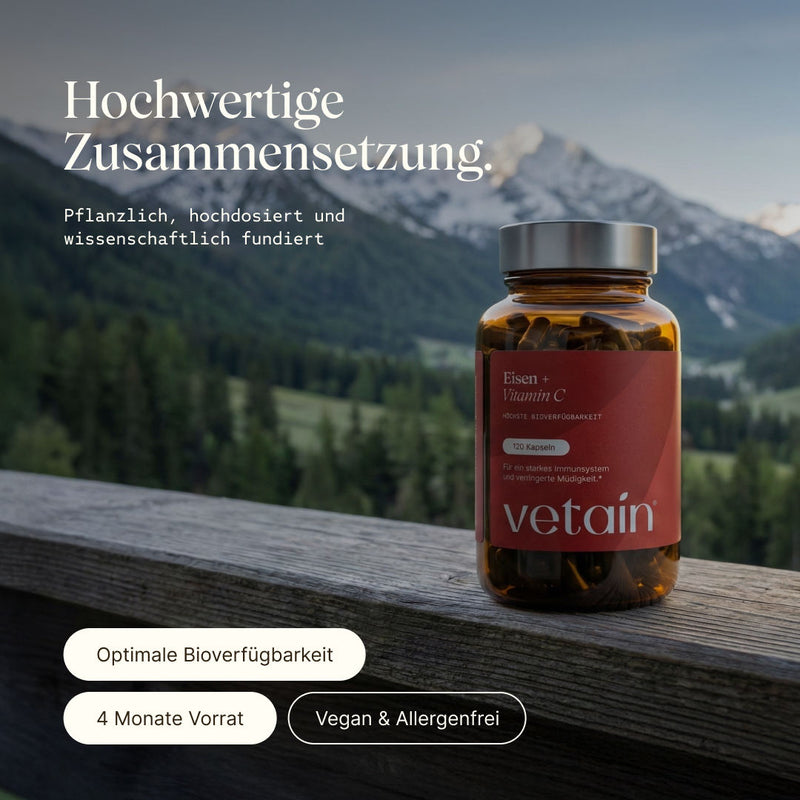 Vetain Eisen + Vitamin C Supplement. Hochwertige Zusammensetzung. Pflanzlich, hochdosiert und wissenschaftlich fundiert. Optimale Bioverfügbarkeit, 4 Monate Vorrat, vegan & allergenfrei. Supplement steht auf einem Holzbacken, im Hintergrund Berglandschaft.