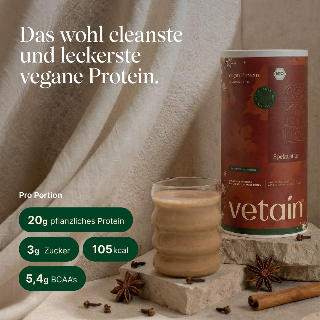 Vetain Proteinpulver vegan. Geschmack Spekulatius mit 20g pflanzlichem Protein, 3g Zucker, 105kcal und 5,4 BCAA's pro Portion. Rote Dose Spekulatius Proteinpulver, daneben ein Glas mit einem cremigen Proteinshake