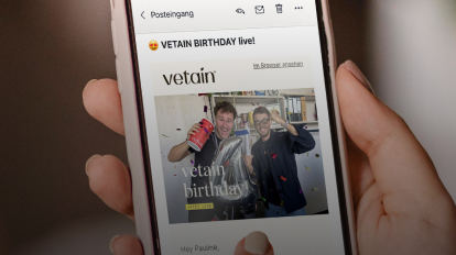 Handy wird in der Hand gehalten, auf dem Handy ist die Vetain Website zu sehen