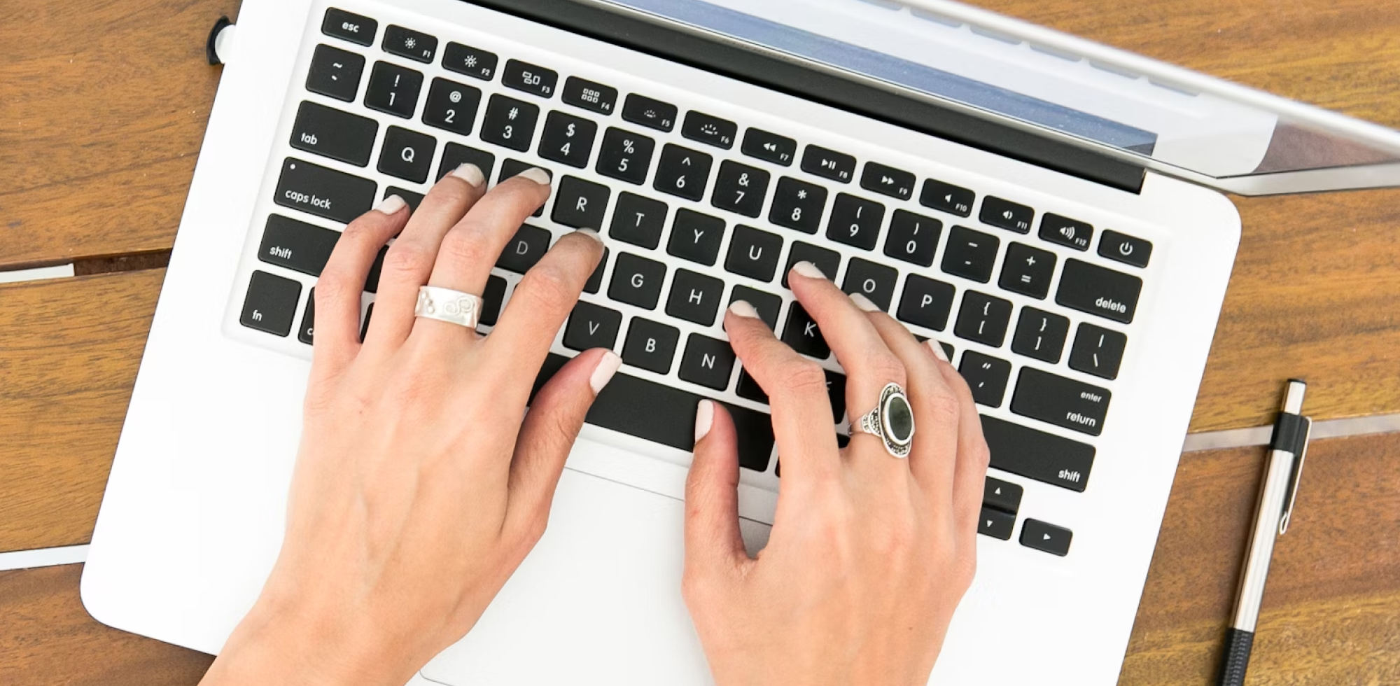 Hand tippt auf Laptop-Tastatur